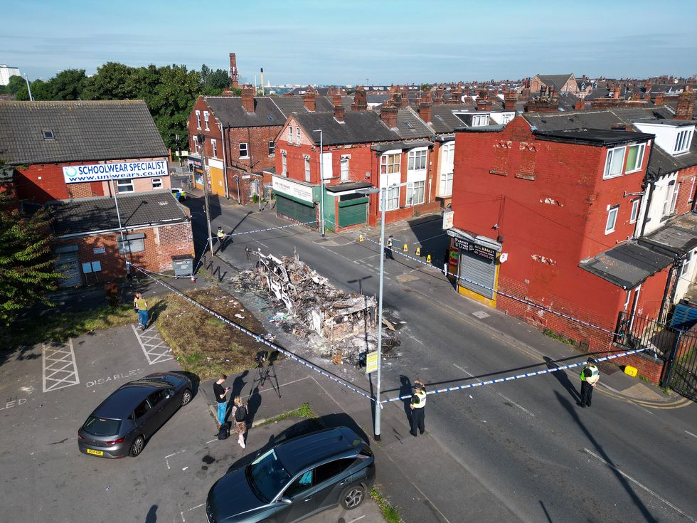 \u200b Police tape cordons off the remains of a burnt out bus in Harehills