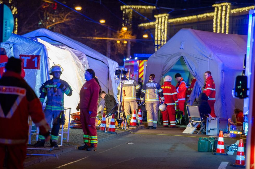 \u200b Police vans and ambulances stand next to the annual Christmas market in the city centre