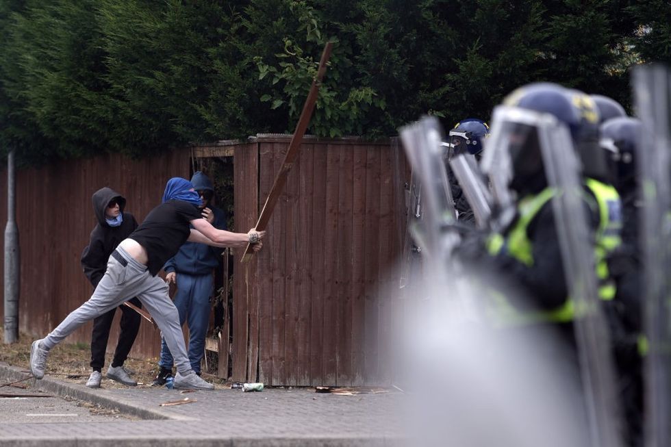 \u200b Riot police clash with anti-migration protesters outside of the Holiday Inn Express in Manvers