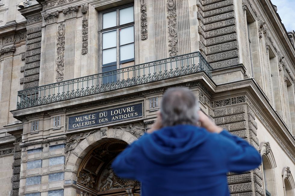 \u200ba broken window protected by a wooden panel at the Louvre Museum