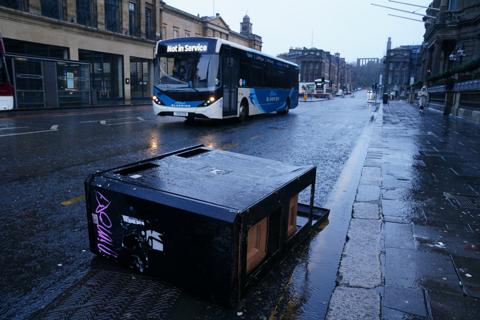 \u200bA bus drives around bins blown over by the winds from Storm Eowyn on Princes Street, Edinburgh