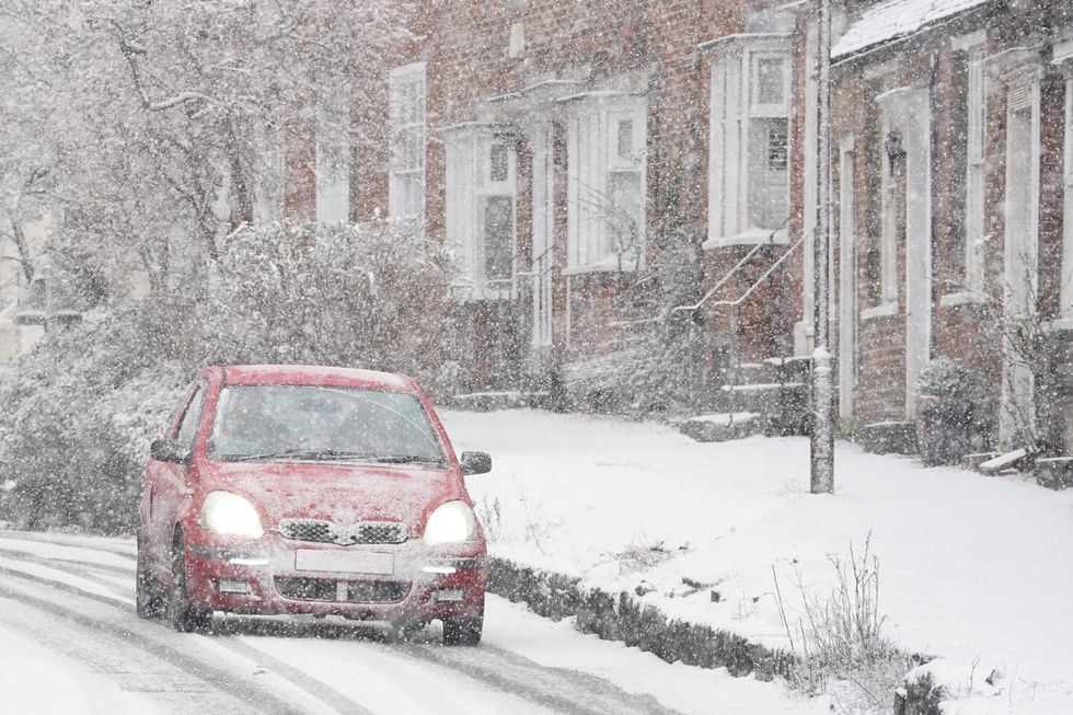 \u200bA car driving through a snow flurry in Lenham, Kent.
