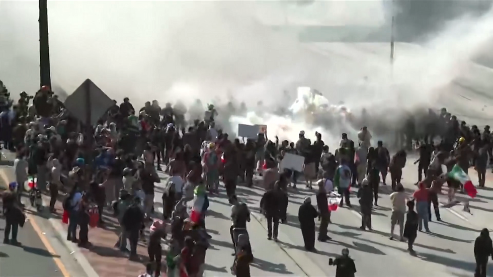\u200bA cloud of tear gas surrounds protesters