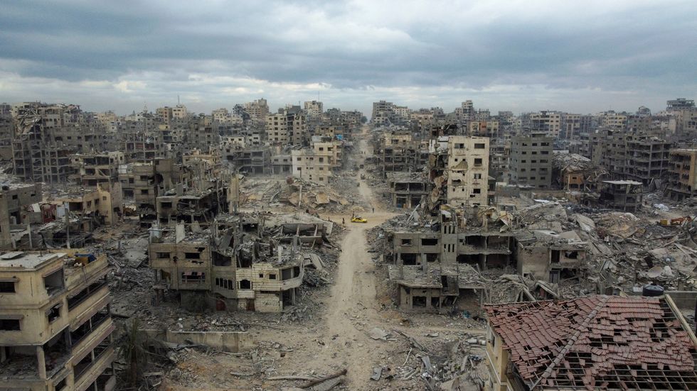 \u200bA drone view shows Palestinians walking past rubble following the withdrawal of the Israeli forces from Gaza City