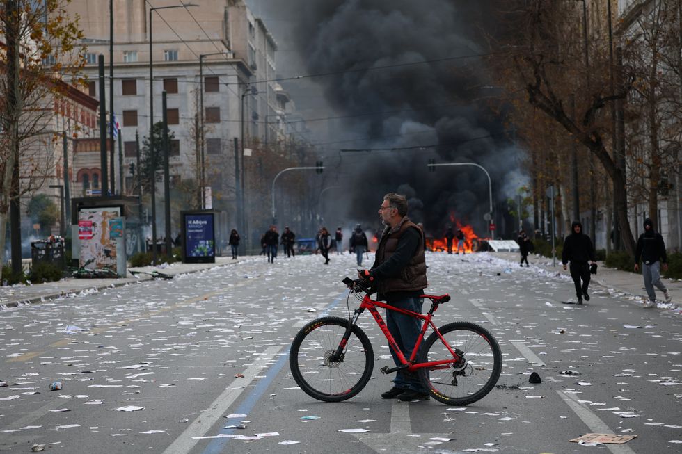 \u200bA fire burns during clashes with riot police outside the Greek parliament