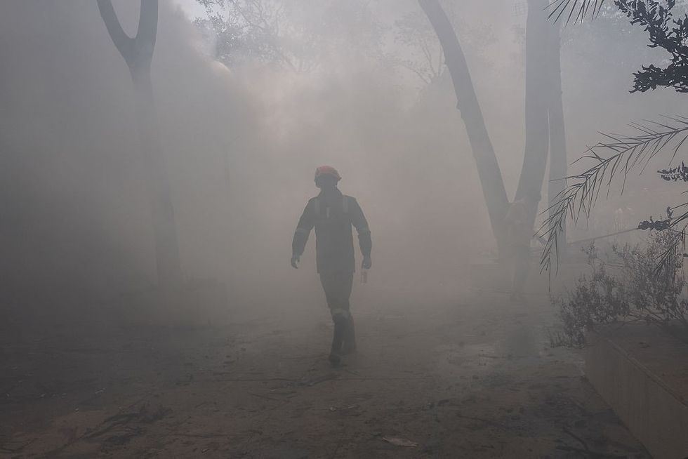 \u200bA firefighter works at the site where Air India flight 171 crashed in a residential area