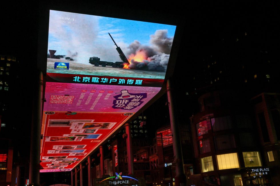 \u200bA giant screen shows a news report on China's "Justice Mission 2025" military drills around Taiwan, in Beijing