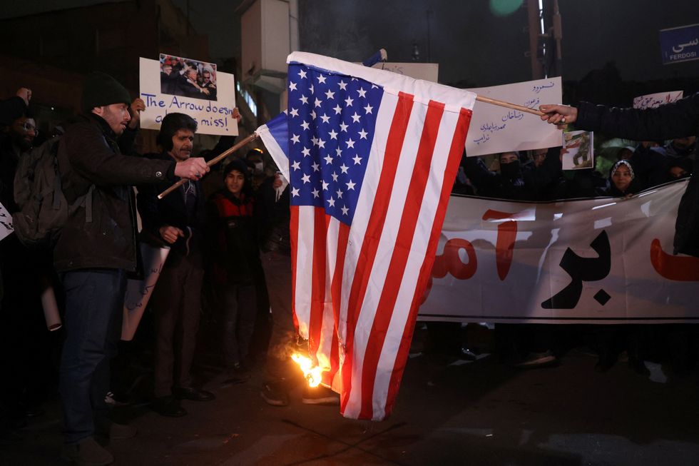 \u200bA group of Iranian students burn the U.S. flag during a protest in front of the British embassy