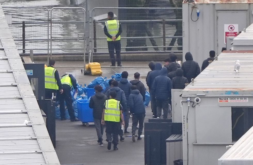 \u200bA group of people thought to be migrants walk through the Border Force compound in Dover, Kent,