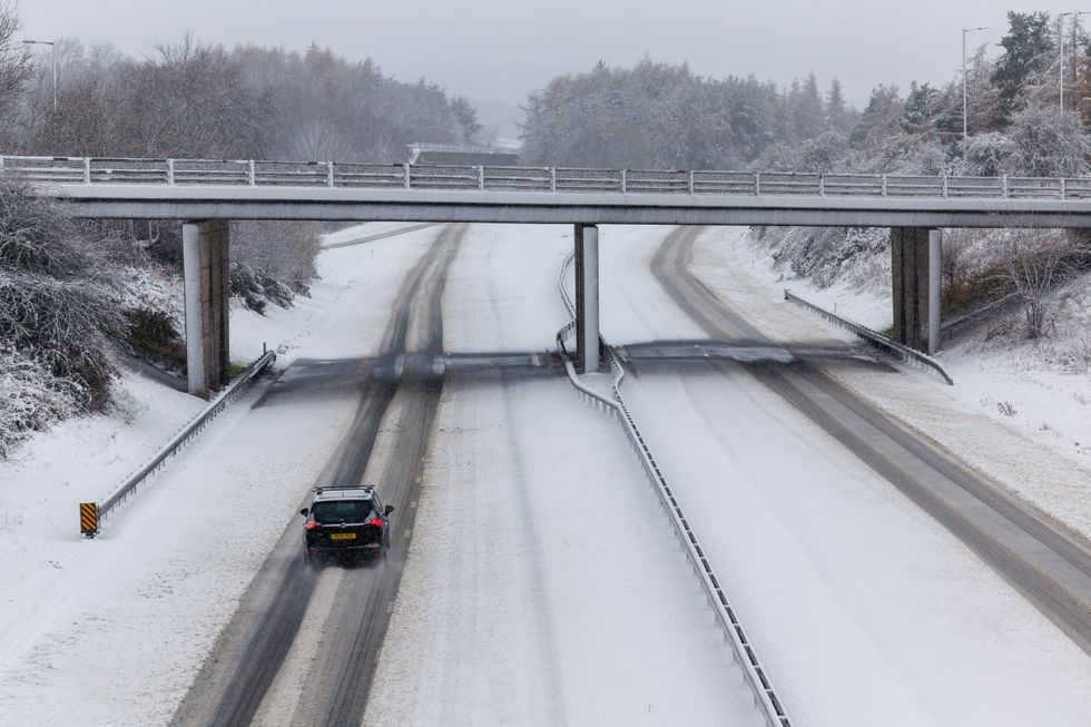 \u200bA lone vehicle is driven along the snow covered M9 motorway near Stirling.