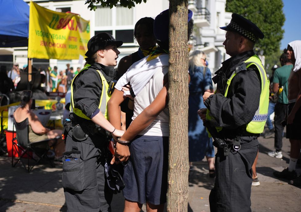 \u200bA man being arrested at the Carnival by officers