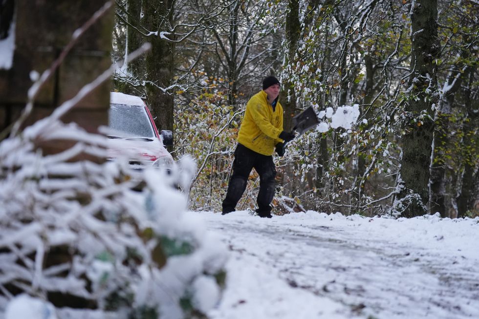 \u200bA man clearing snow in Durham