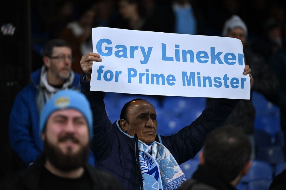 \u200bA Manchester City fan holds a banner reading "Gary Lineker for Prime Minister" before match