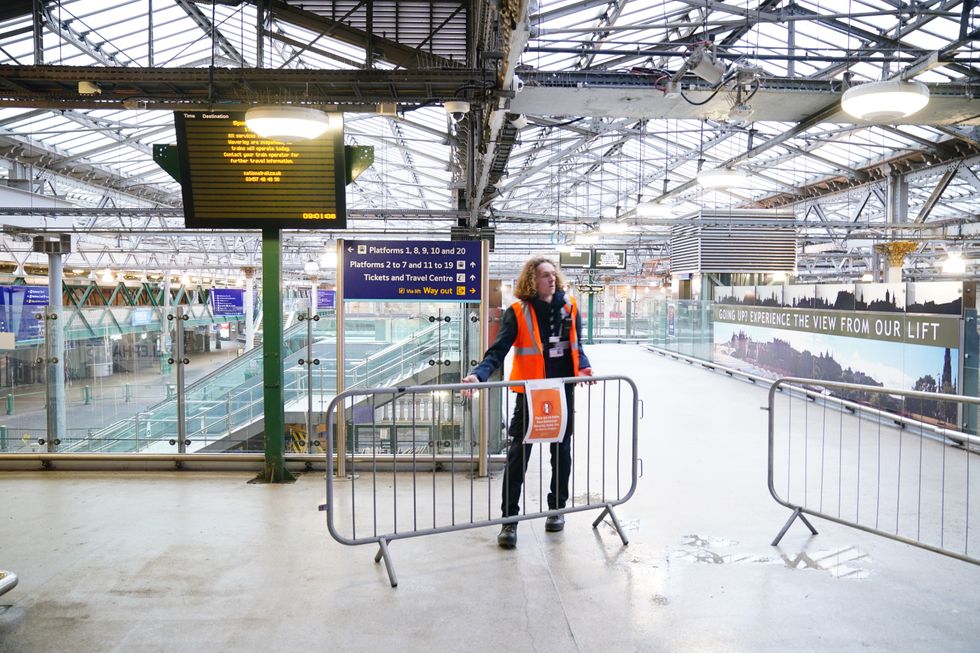 \u200bA member of staff places barriers and closes the entrance to Waverley Station in Edinburgh