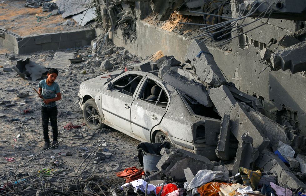 \u200bA Palestinian boy stands next to a damaged car at the site of an Israeli strike on a house, in Jabalia, northern Gaza Strip