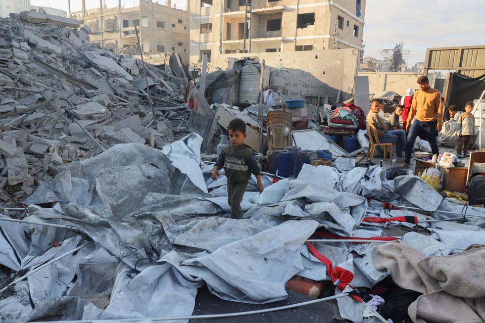 \u200bA Palestinian child walks at the site of an overnight Israeli strike on a house, in Gaza City