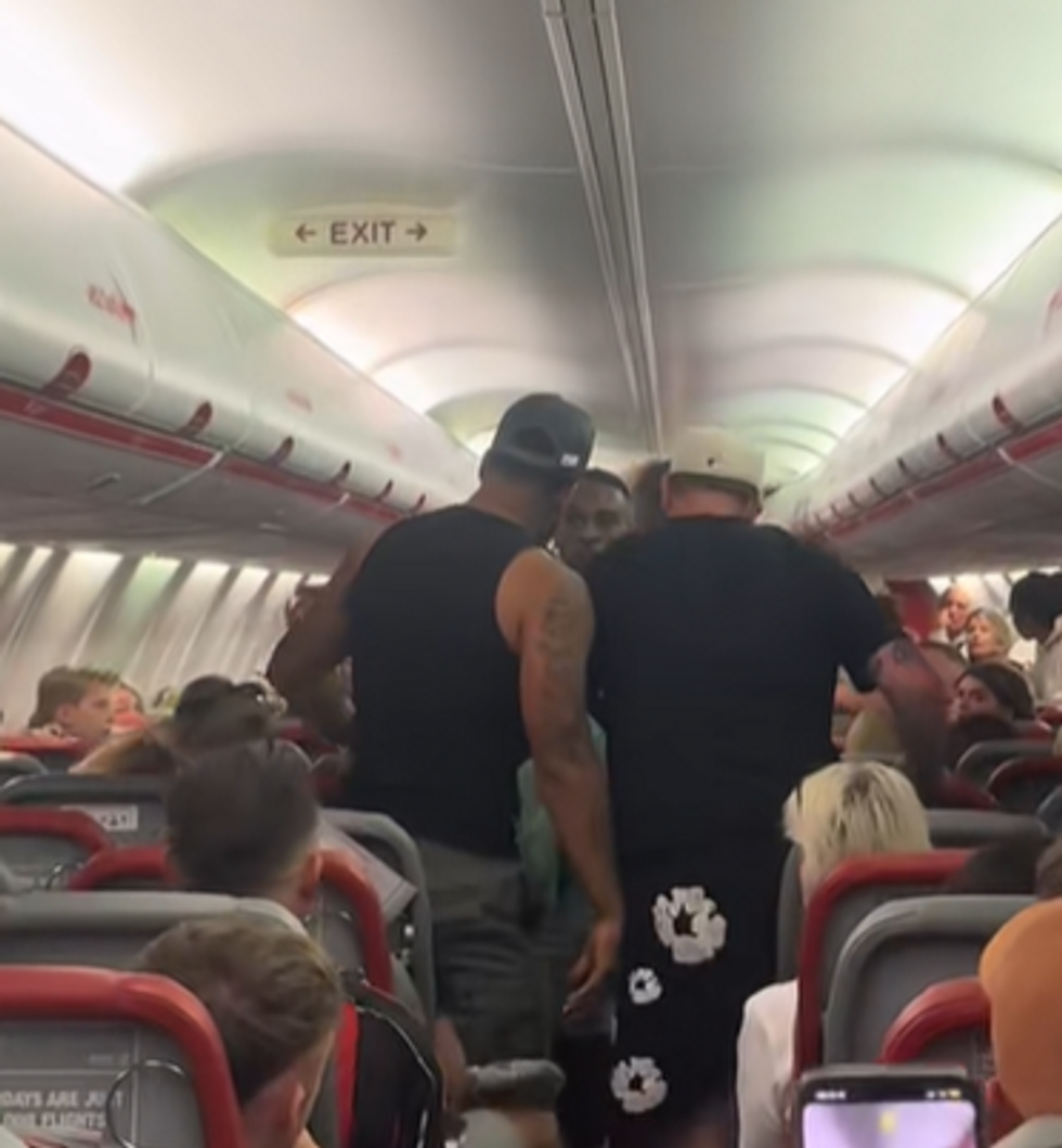 \u200bA passenger gets himself in the way between two men