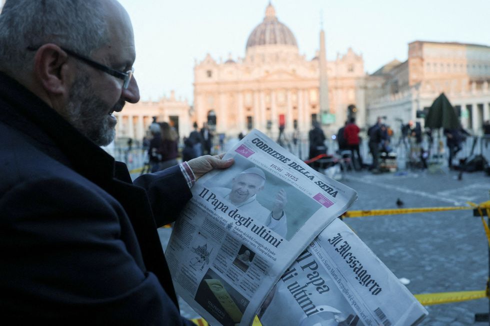 \u200bA person holds newspapers with pictures of Pope Francis, following his death