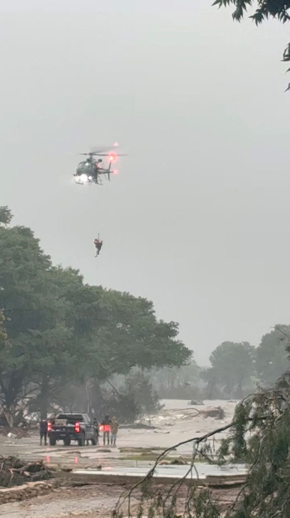 \u200bA person is rescued via helicopter from the flash floods