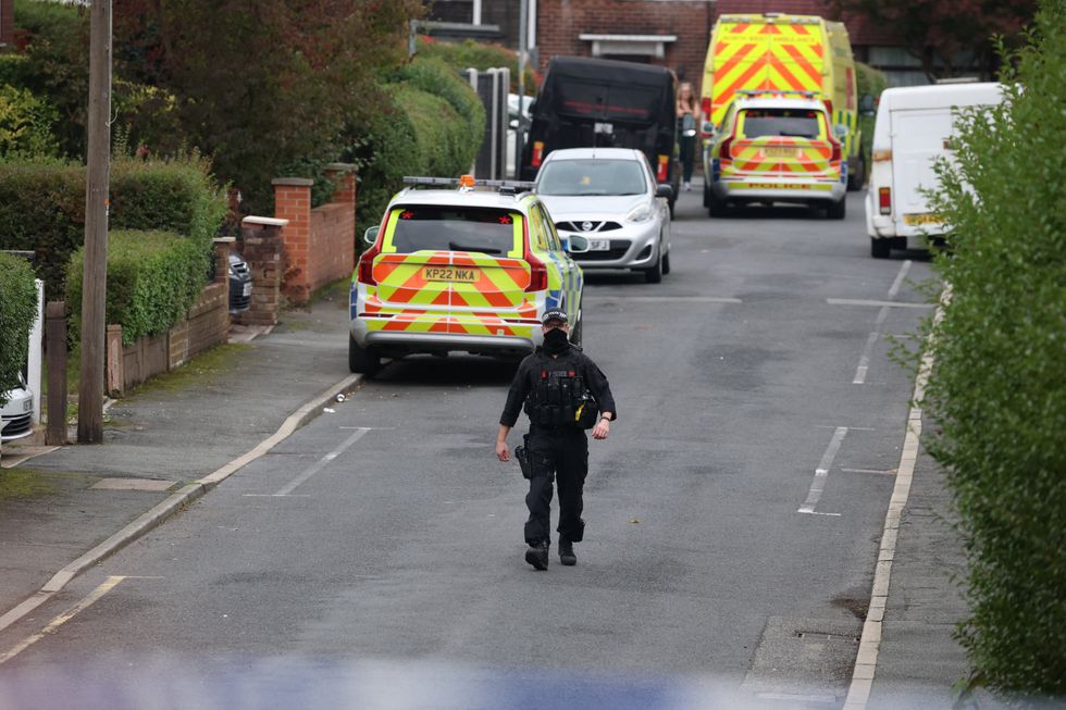 \u200bA police officer walks along a road which was cordoned off, close to the scene