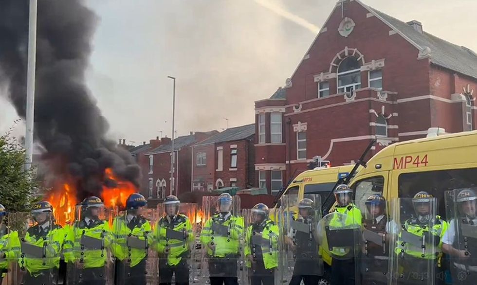 \u200bA police van set alight as trouble flares in Southport