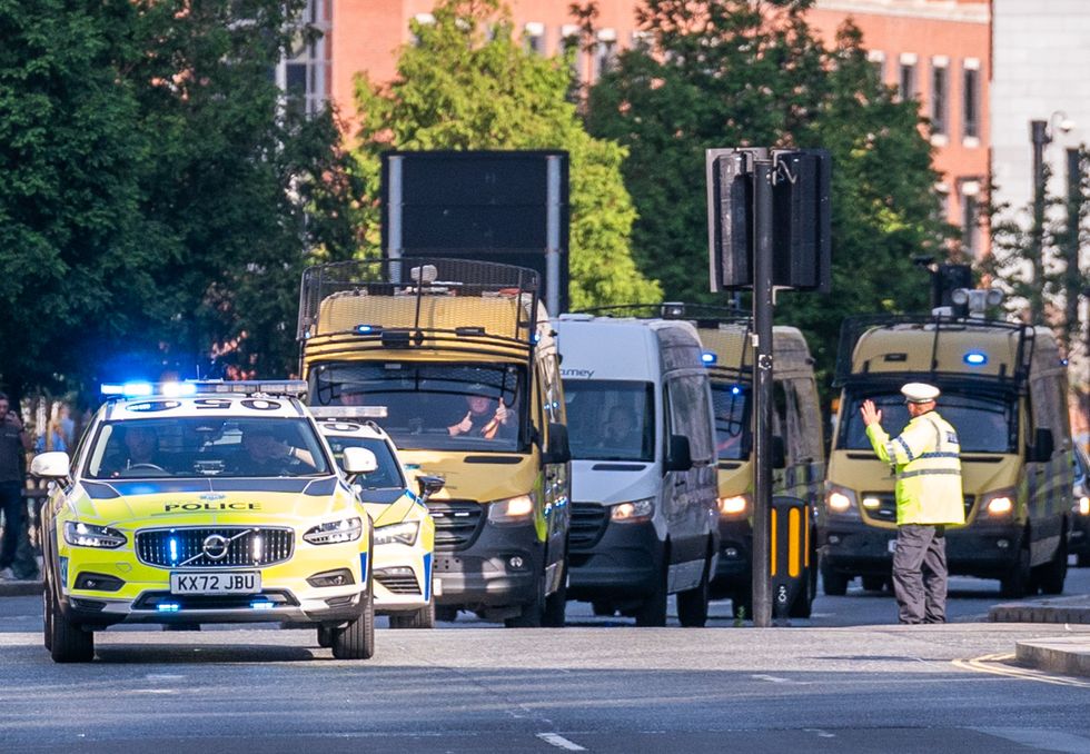\u200bA prison van escorted by multiple police vehicles
