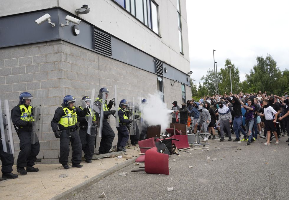 \u200bA protester uses a fire extinguisher on police officers as trouble flares