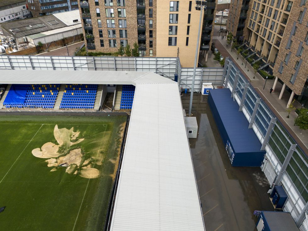 \u200bA sinkhole on the pitch and flooded walkways at the Cherry Red Records Stadium, home of AFC Wimbledon