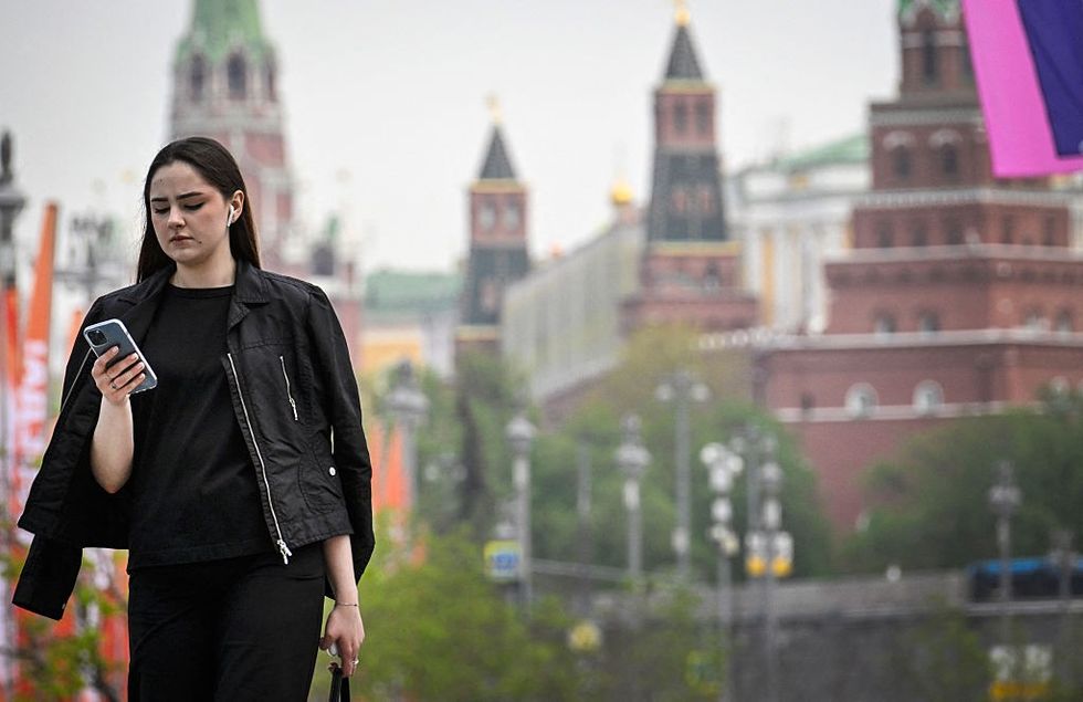 \u200bA woman walks in front of the Kremlin in Moscow on April 23, 2025.