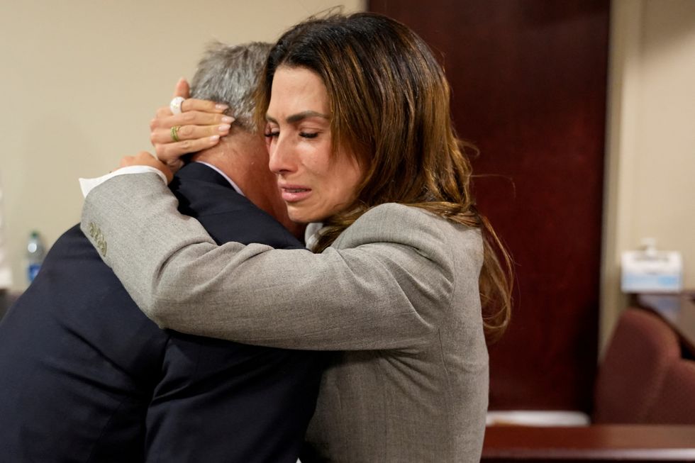 \u200bAlec Baldwin and his wife Hilaria Baldwin embrace following the dismissal