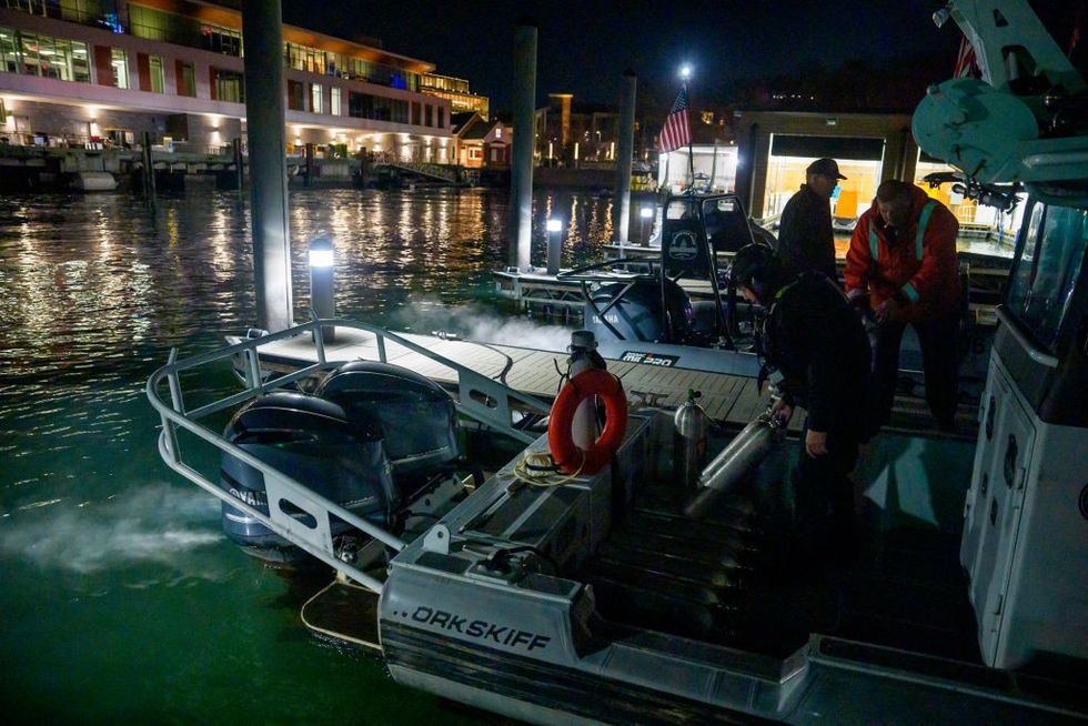 \u200bAn emergency response team with Washington, DC Fire and EMS and DC Police load diving equipment on a boat to continue working the scene of airplane wreckage
