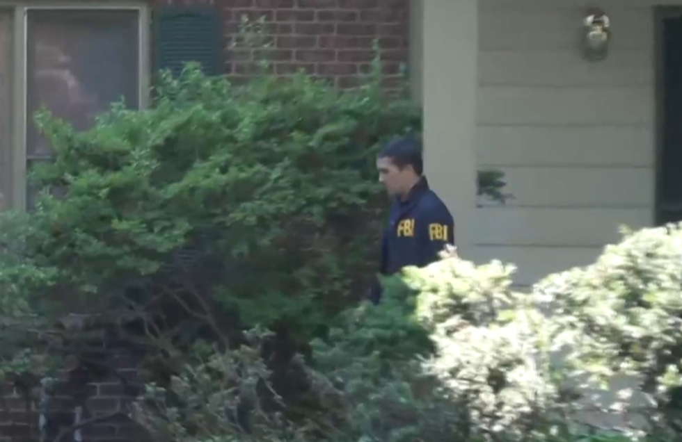 \u200bAn FBI agent leaving Mr Bolton's house