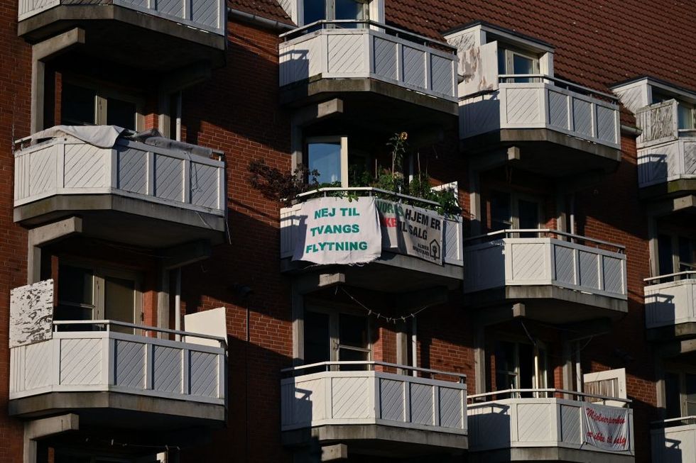 \u200bBanners with texts reading 'No to forced relocation' and 'Our homes are not for sale' are seen hanging out on a balcony of a residential building at Mjolnerparken housing estate in Copenhagen,