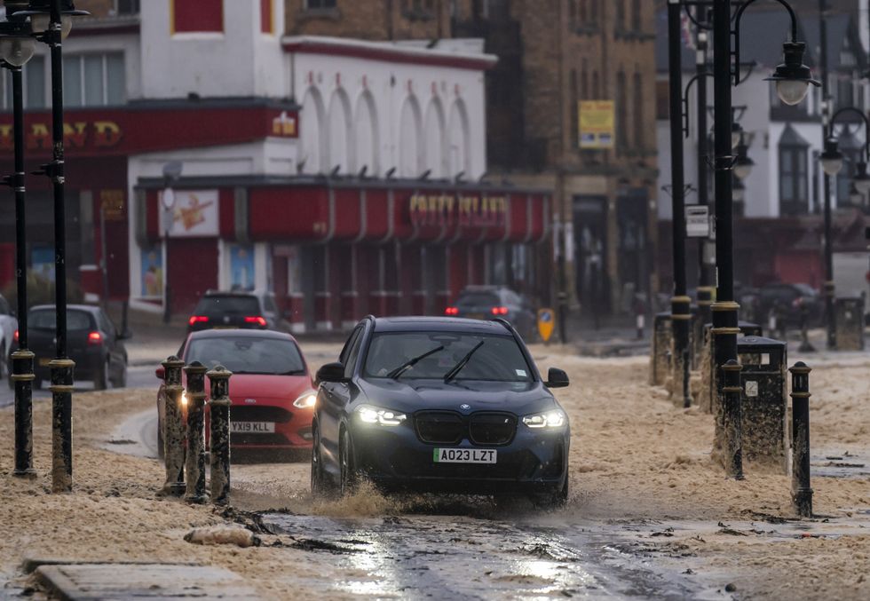\u200bCars drive through Storm Babet flood waters