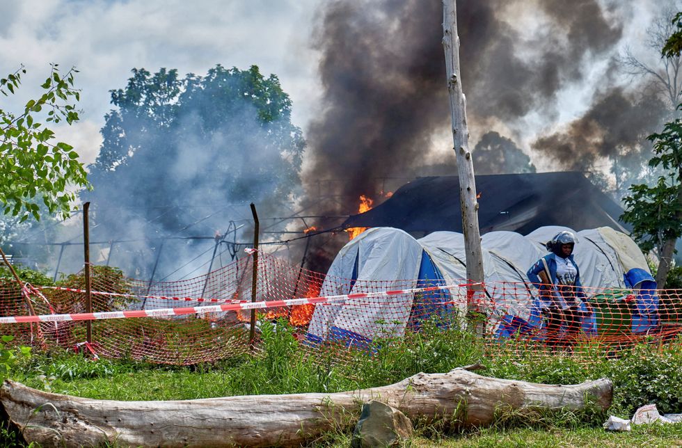 \u200bCongolese police personnel stood guard at the burning Ebola treatment center