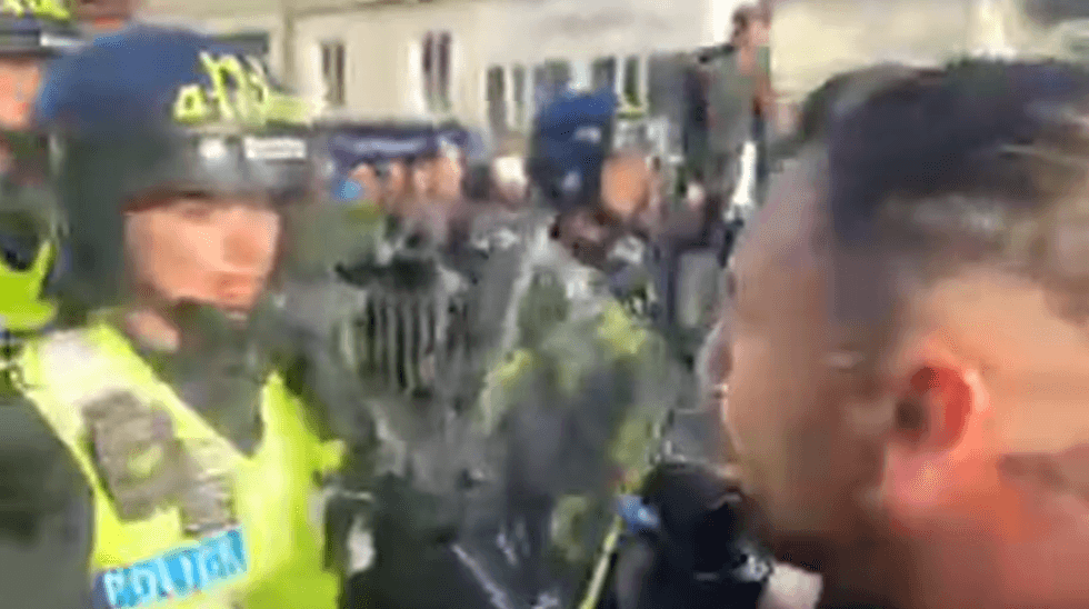 \u200bDaniel Thomas aka Danny Tommo confronting a riot police officer during the protests