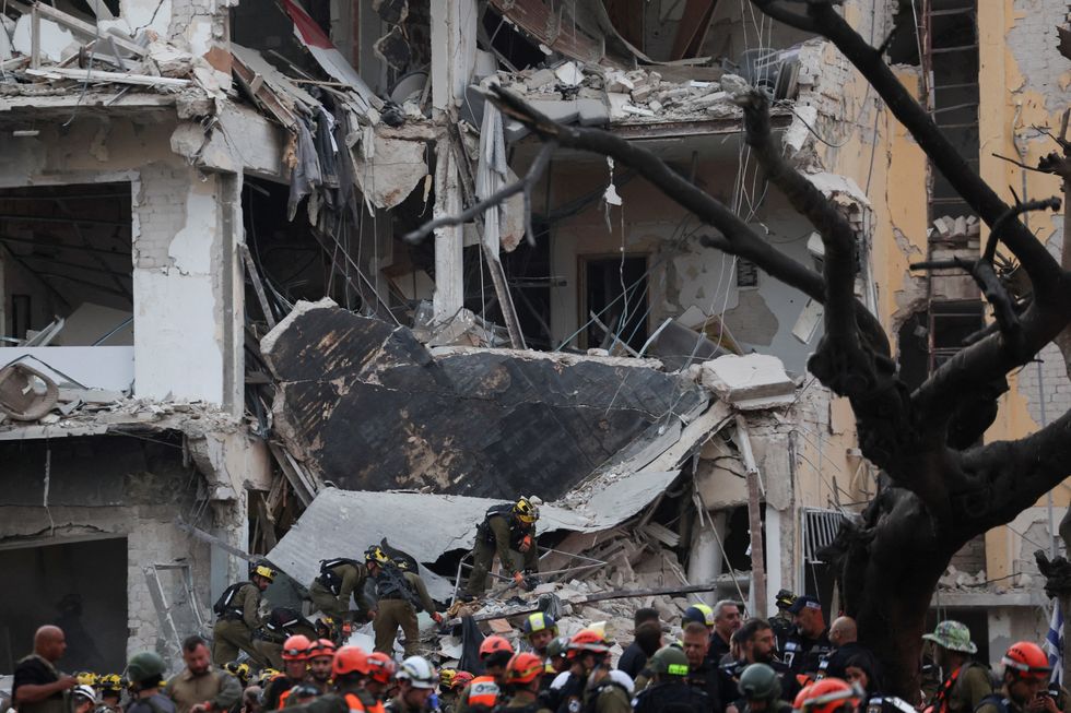 \u200bEmergency personnel work at an impact site following a missile attack from Iran on Israel, in Tel Aviv