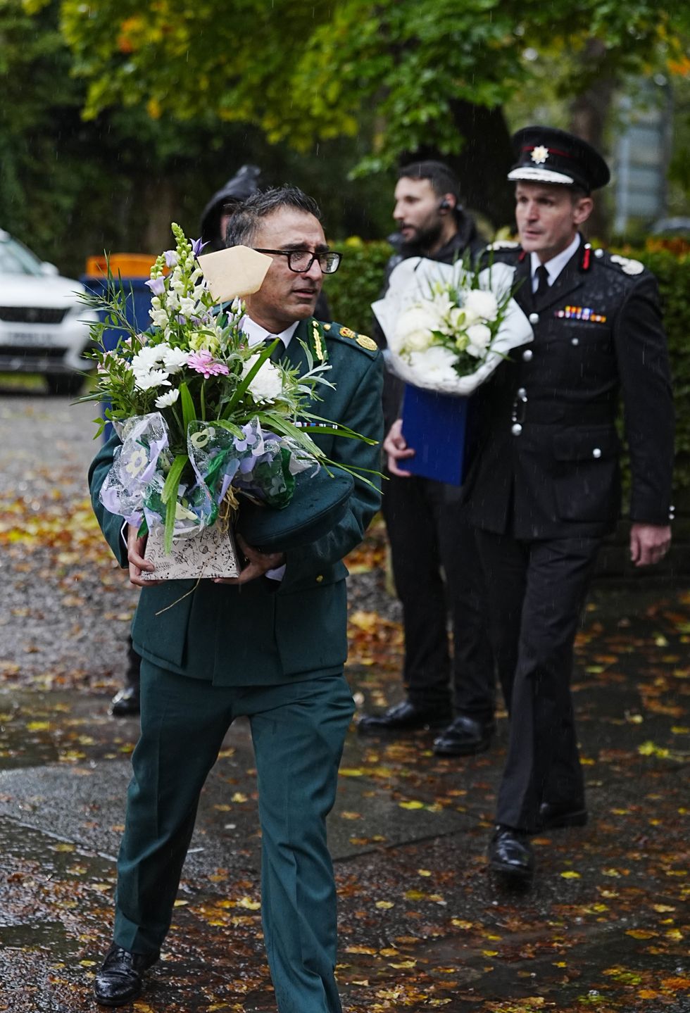 \u200bEmergency workers lay down flowers at the vigil