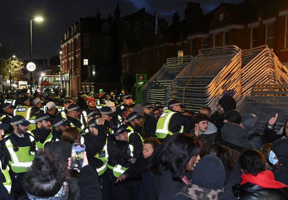 \u200bemonstrators clash with police officers near a Kurdish community centre
