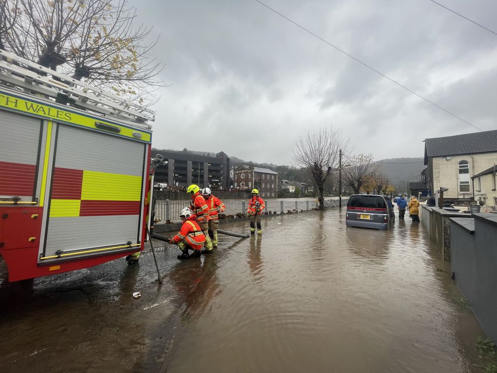 \u200bFirefighters pumping water from a street by the River Taff, in Pontypridd, Wales, following flooding
