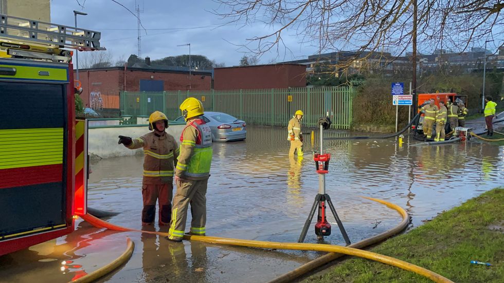 \u200bFirefighters work to pump water away from flooded residential streets near Moat Park in Dundonald on the outskirts of Belfast.