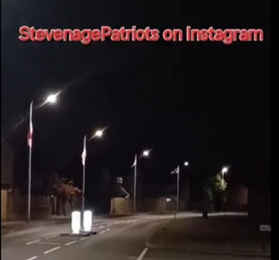 \u200bFlags can be seen across the street which the men were putting up