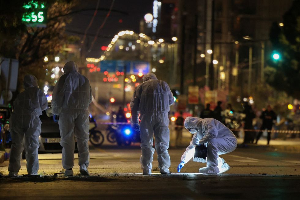 \u200bForensics officers investigate the area of a bomb blast outside the Hellenic Train offices, in Athens, Greece