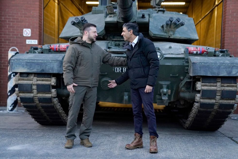 \u200bFormer PM Rishi Sunak and Ukrainian President Zelensky meet Ukrainian troops being trained to command Challenger 2 tanks at a military facility in February