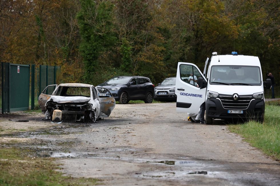 \u200bFrench gendarmes work near the burnt car used by a driver