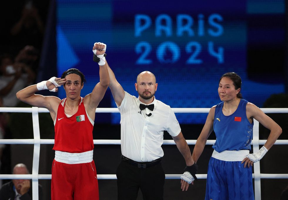 \u200bImane Khelif salutes as the referee raises her hand