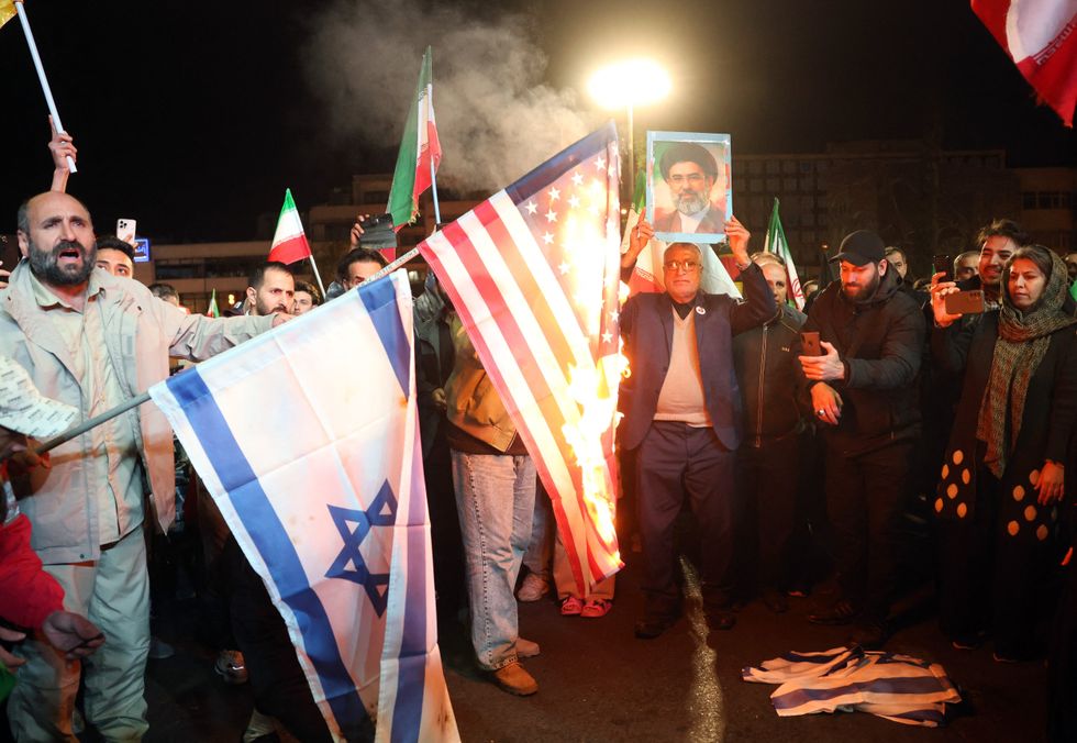 \u200bIranians burn US and Israeli flags as react after the ceasefire announcement at the Enqelab square, in Tehran on April 8