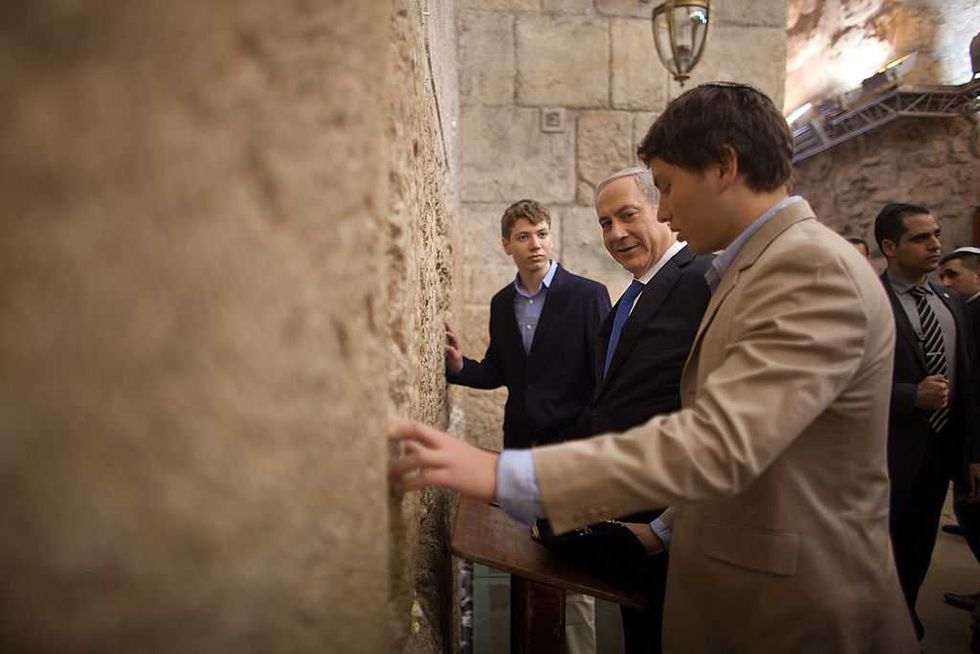 \u200bIsraeli Prime Minister Benjamin Netanyahu prays with his sons Yair and Avner