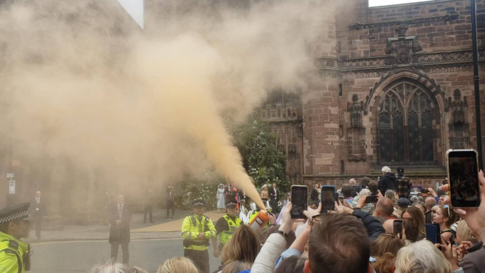 \u200bJSO protesters let off orange smoke from fire extinguishers outside the cathedral