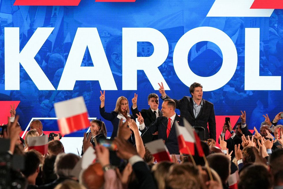 \ U200bkarol Nawrocki, podpořená stranou hlavního opozičního práva a spravedlnosti (PIS), gesta vedle své manželky Marty Nawrocka